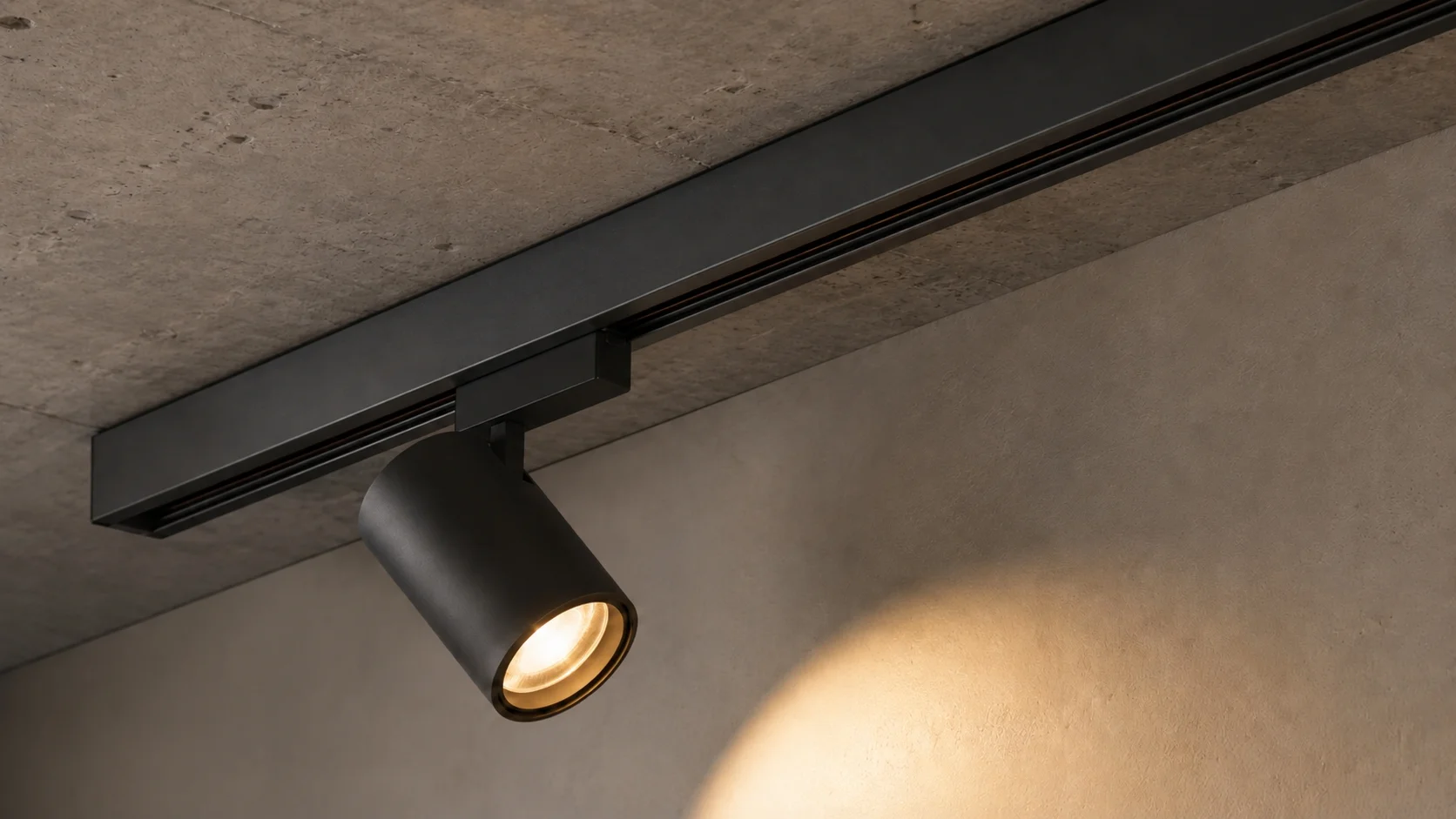 Surface-mounted magnetic track lighting on concrete ceiling with spotlight module and visible mounting brackets